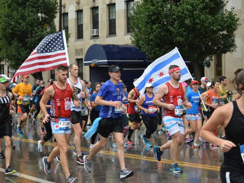 Marathon runners carrying American and Chicago flags