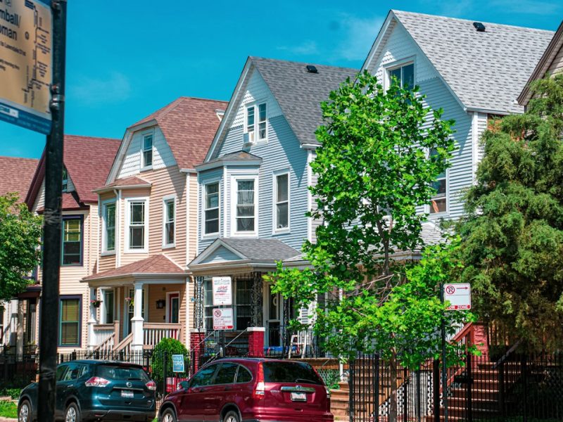 A row of houses on a residential street with cars parked out front