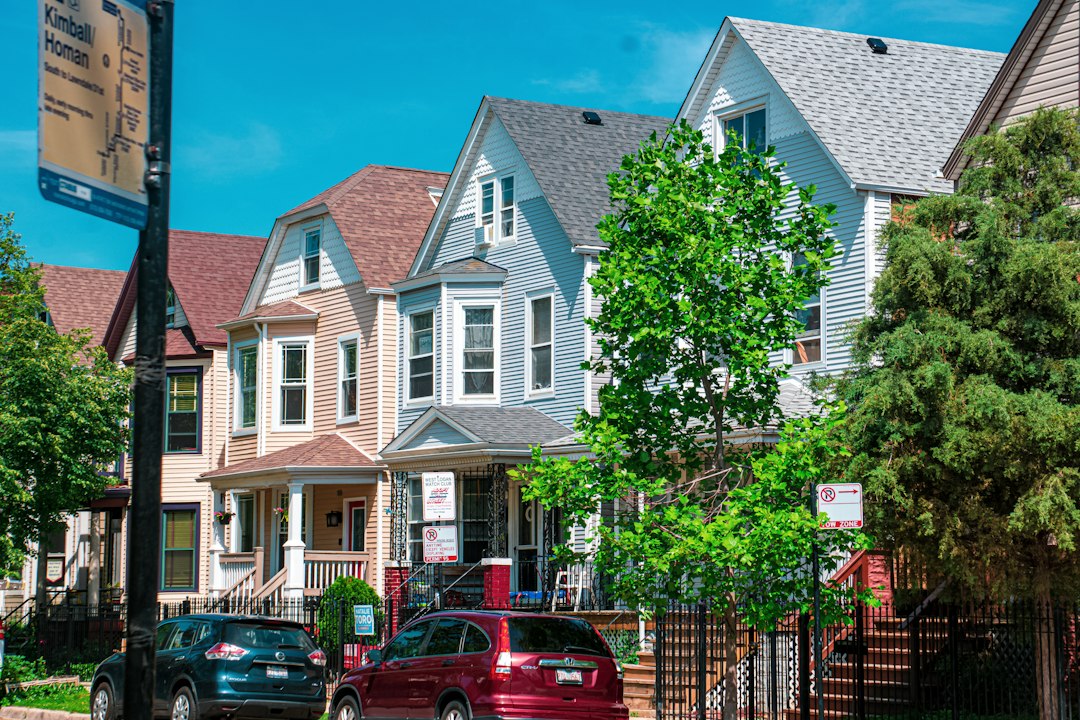 A row of houses on a residential street with cars parked out front